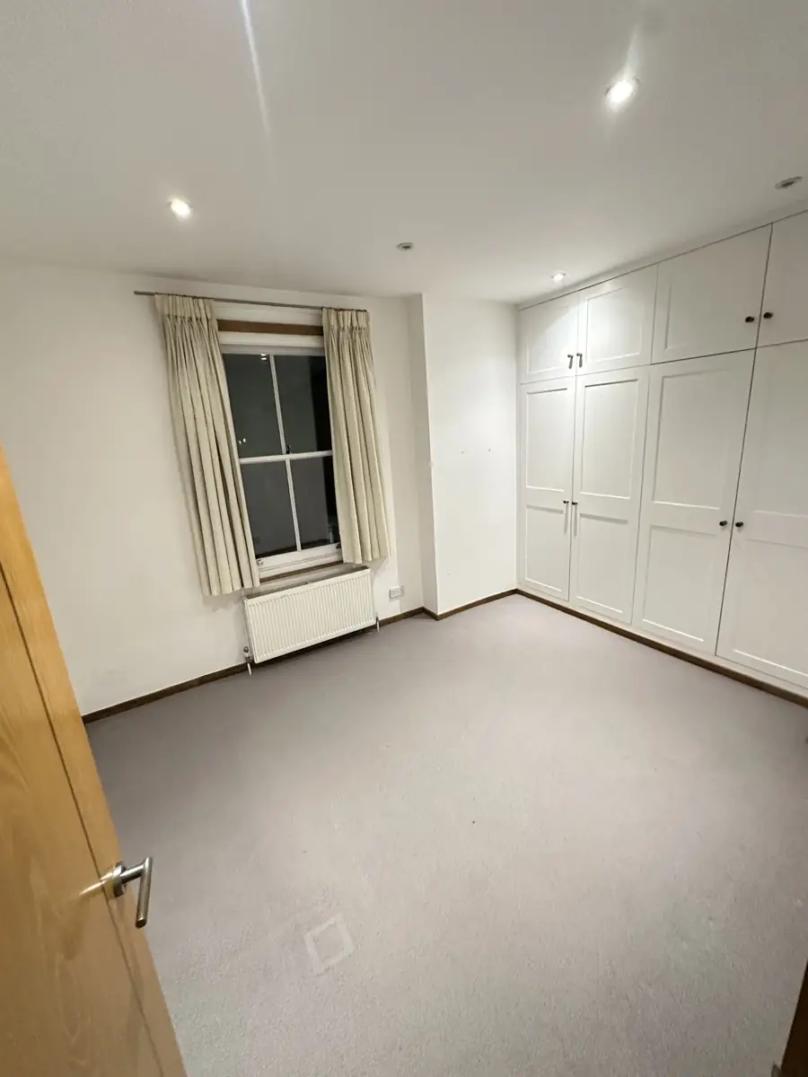 Bedroom before: grey carpet and plain white walls